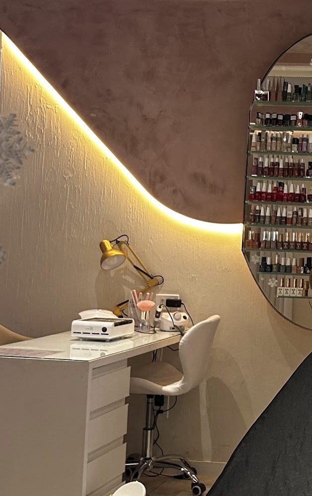 Mesa de manicure com parede ondulada iluminada e expositor de esmaltes
