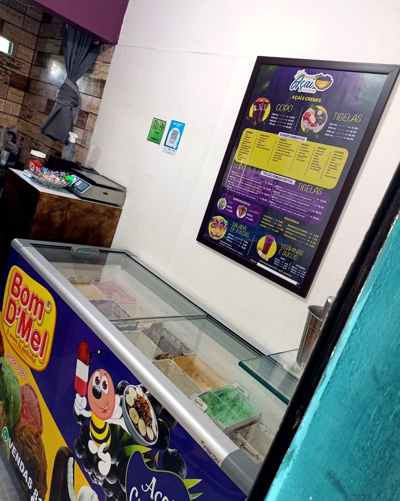 Interior da loja com o freezer de sorvetes e o quadro do cardápio